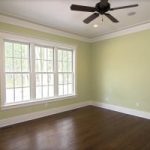 Replacement Windows Hartland WI White windows in a living space with hardwood floors and a ceiling fan