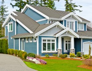 Siding Contractors Milwaukee WI Blue home with many windows and gorgeous landscaping